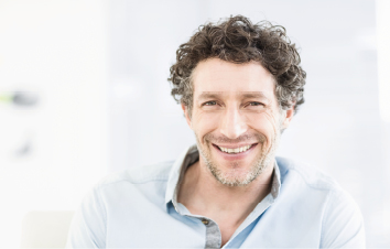 Patient with curly dark hair laughs